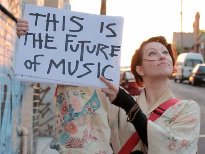 Amanda Palmer holds up a sign reading 'This Is The Future Of Music'